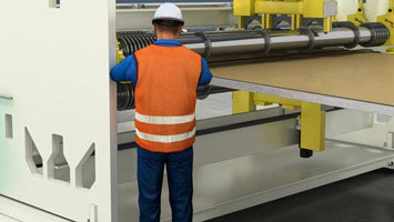 Employee standing in front of paper machine - screenshot from Convergence course